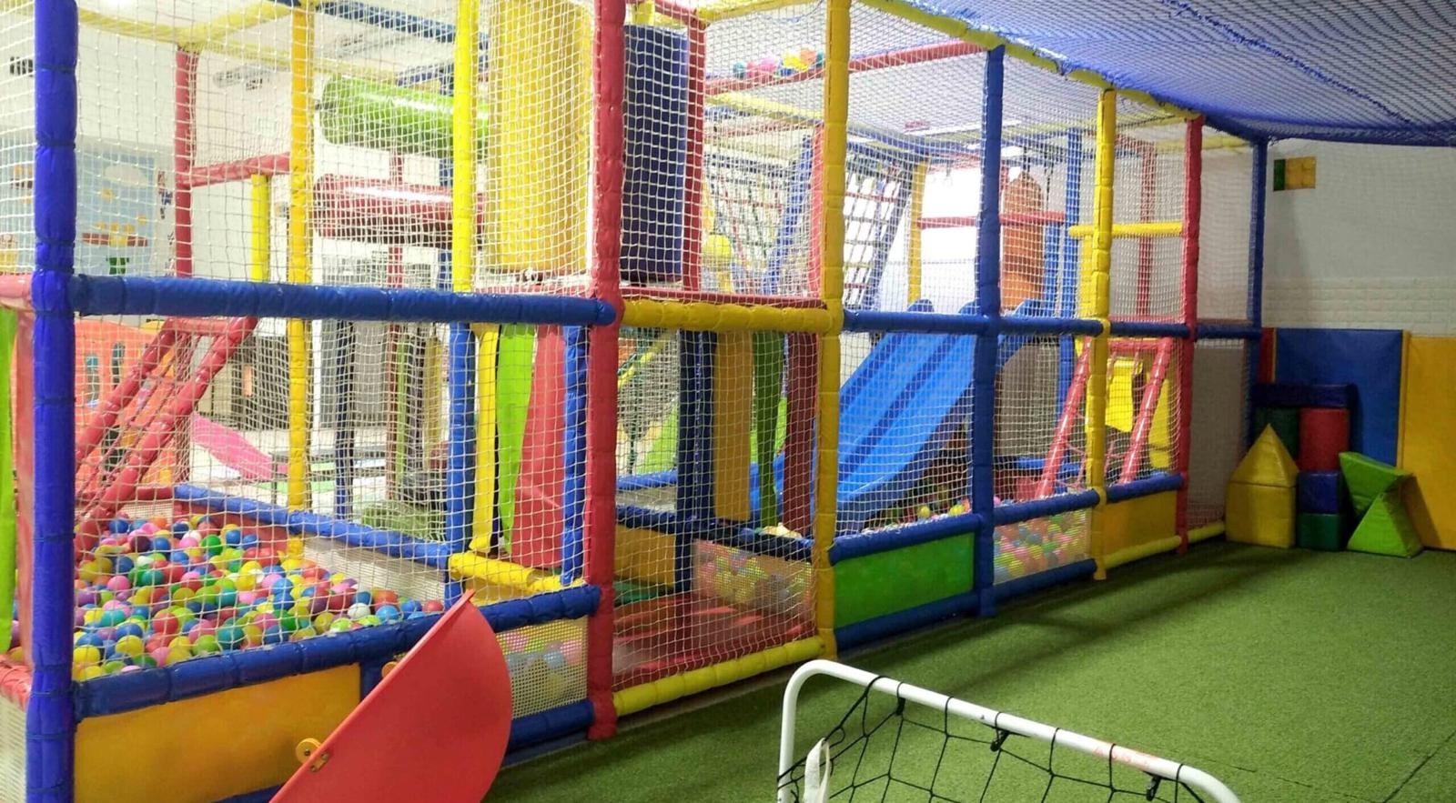 Piscina de bolas de colores junto a la estructura del parque infantil