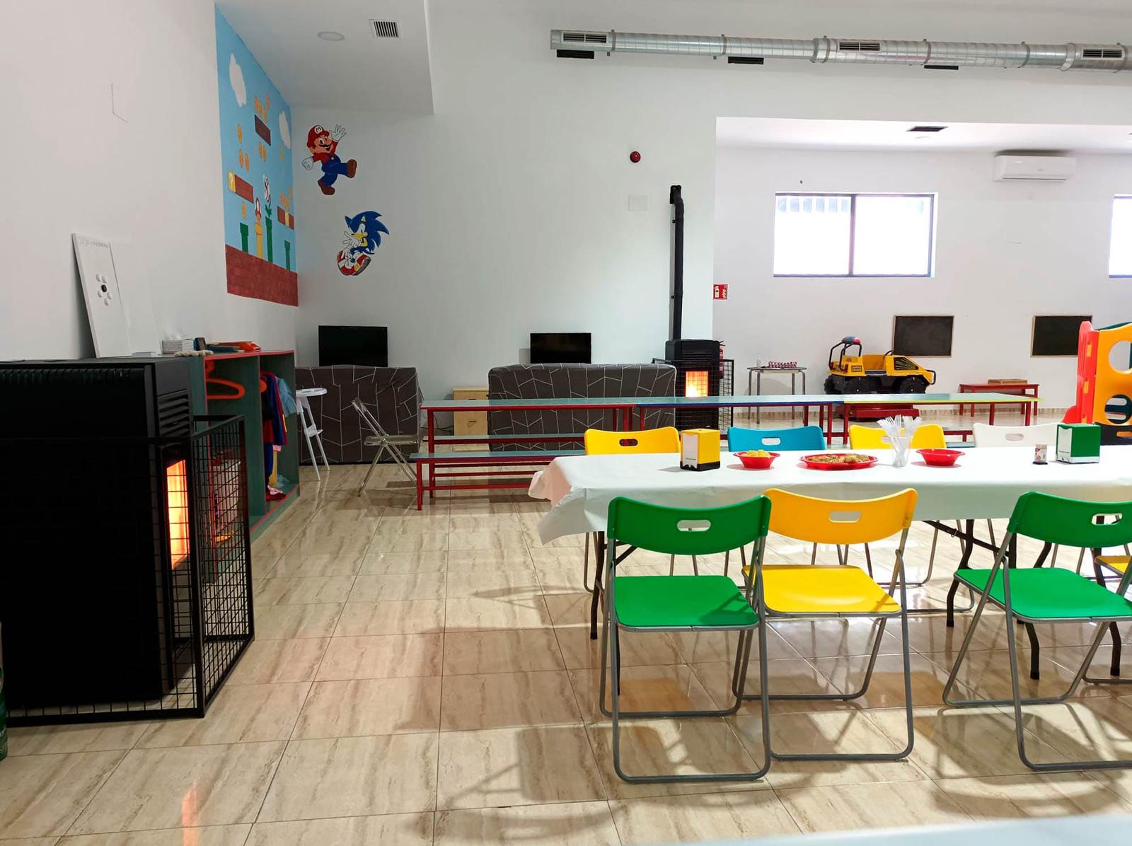 Sala principal con mural de Mario y Sonic, mesas y sillas de colores