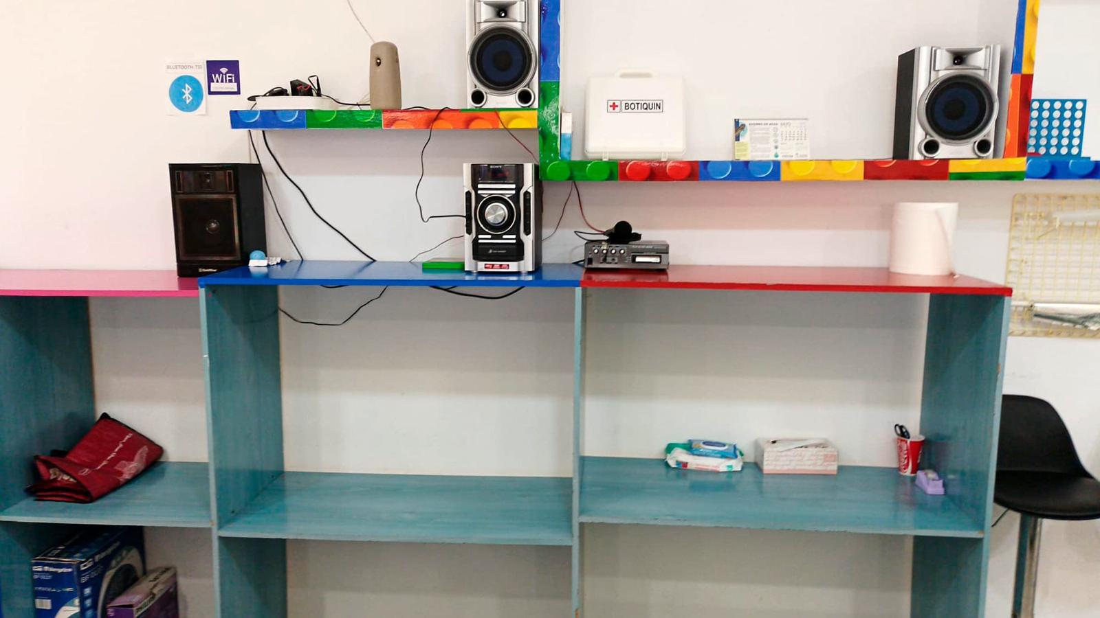 Estantería con equipo de música, botiquín y decoración de bloques de colores