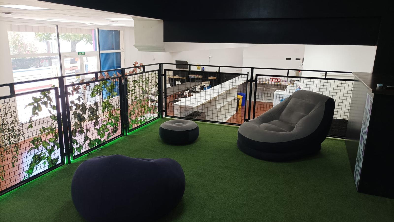 Zona chill out con césped artificial y pufs hinchables en la planta superior